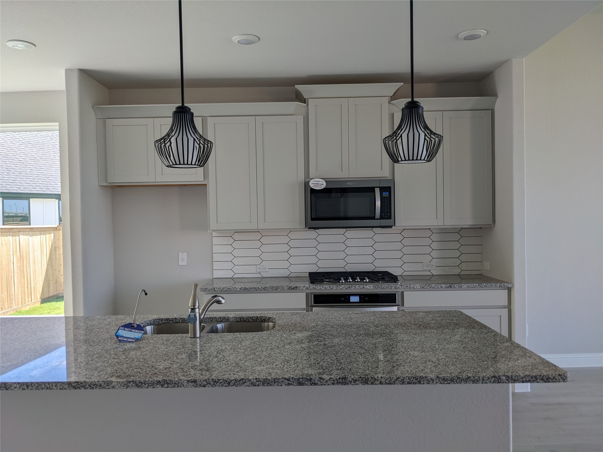 15311 Leal Rancho Court Cypress, TX 77433 - Photo 10 of 20 a kitchen with stainless steel appliances granite countertop a sink a stove and microwave