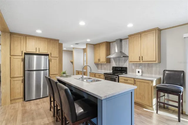 a kitchen with a refrigerator a stove a sink and a dining table