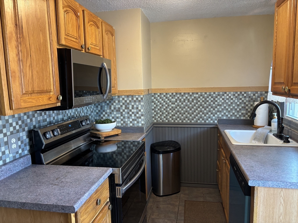 34 Canterbury Road Springfield, MA 01118 - Photo 4 of 34 a kitchen with granite countertop a sink a stove and a microwave