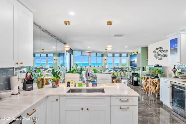 a large white kitchen with lots of counter space and stainless steel appliances