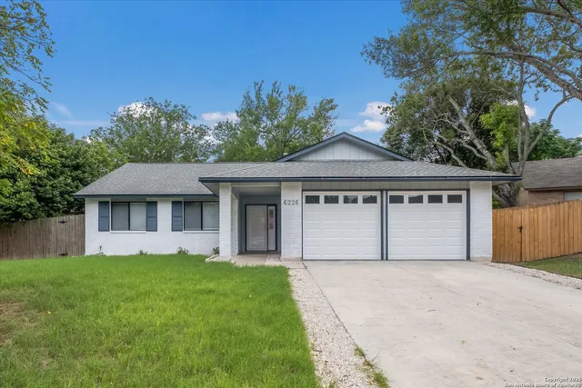 a front view of a house with a garden and yard