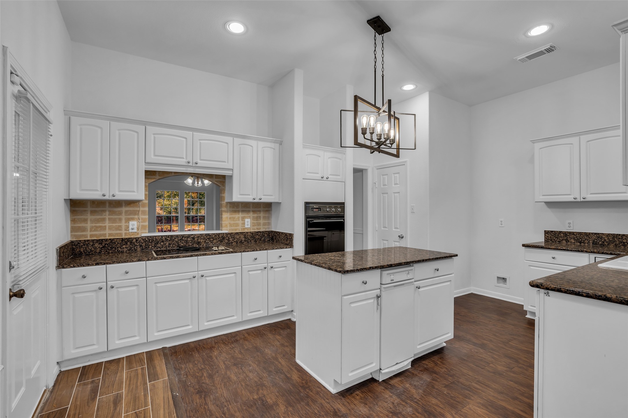 701 Ravensworth Drive Conroe, TX 77302 - Photo 4 of 14 a kitchen with granite countertop a sink a stove and cabinets