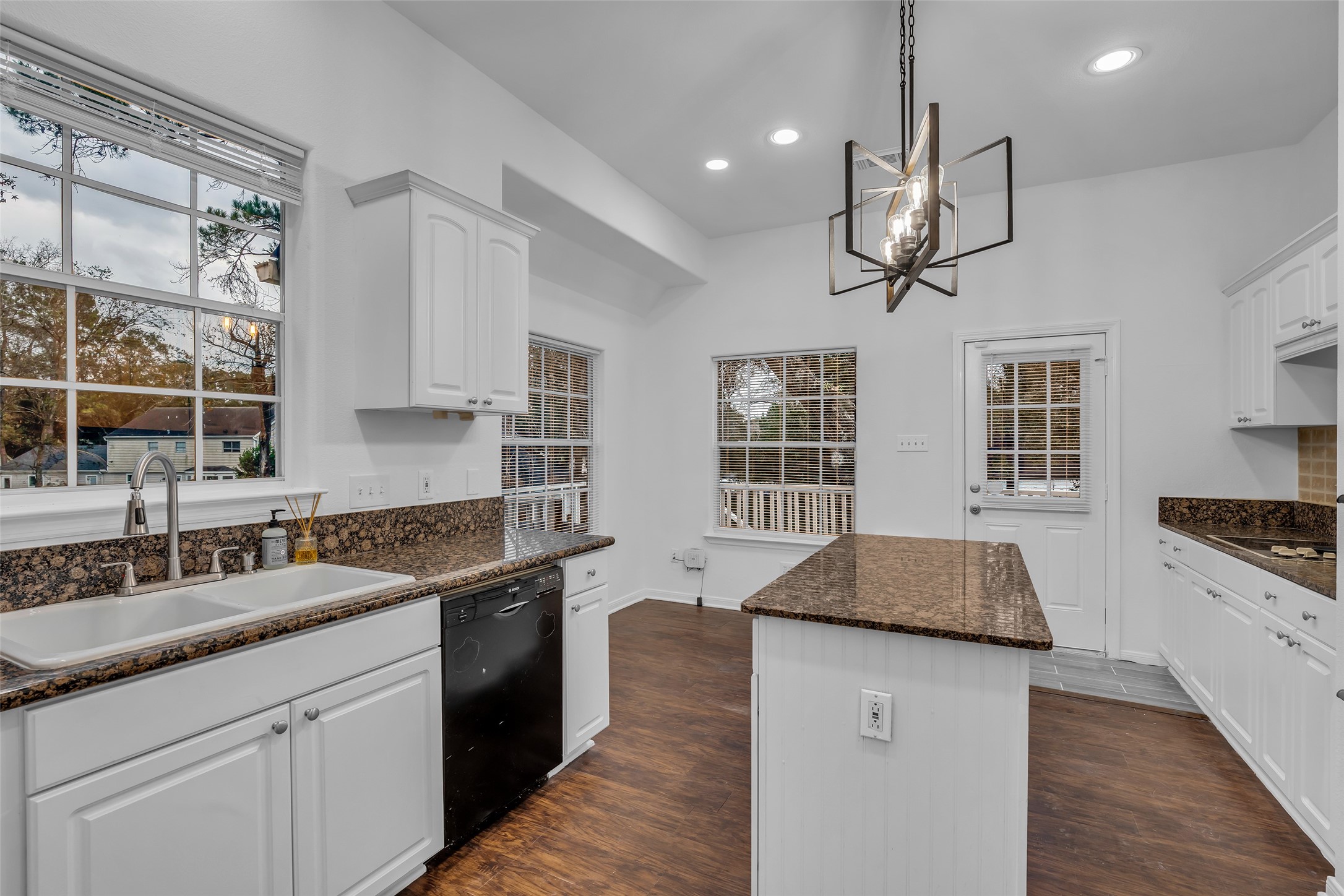 701 Ravensworth Drive Conroe, TX 77302 - Photo 5 of 14 a kitchen with stainless steel appliances granite countertop a sink stove cabinets and wooden floor