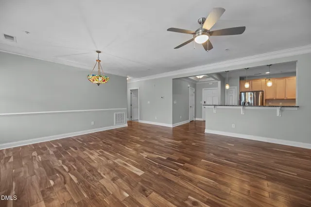 a view of an empty room with a window and a kitchen