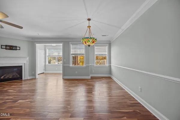 a view of an empty room with window and wooden floor