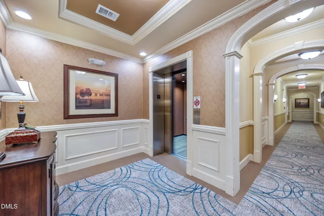 a view of a hallway with wooden floor and cabinet