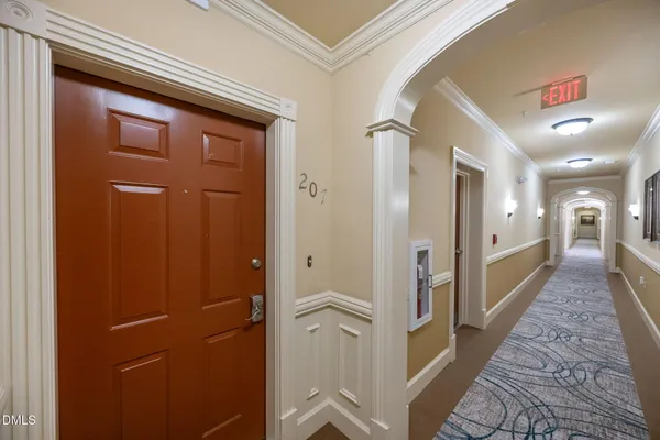 a hallway with wooden floor and staircase