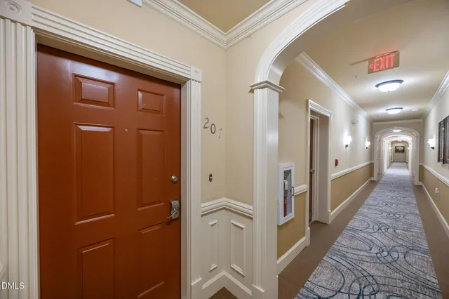 a hallway with wooden floor and staircase