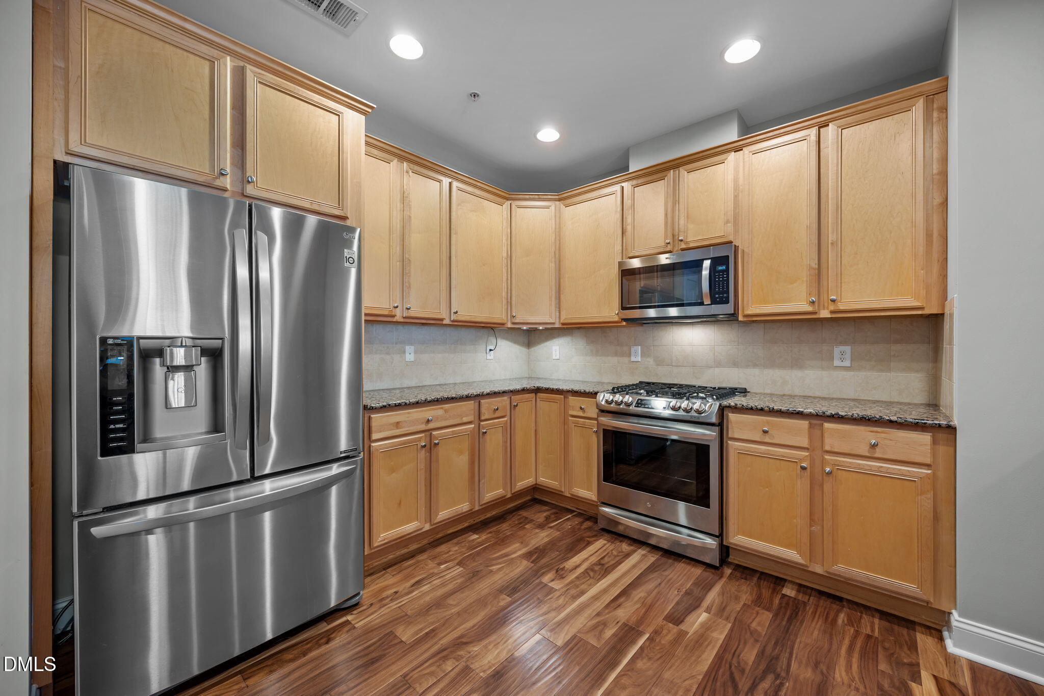 10410 Rosegate Court, Unit 201 Raleigh, NC 27617 - Photo 7 of 46 a kitchen with stainless steel appliances granite countertop a refrigerator a stove top oven a sink and dishwasher with wooden floor
