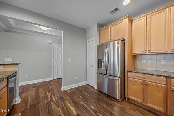 a kitchen with wooden floors and refrigerator