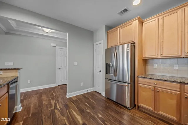 a kitchen with wooden floors and refrigerator