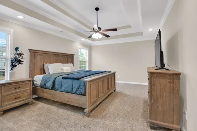 a bedroom with a bed a chandelier and a dresser