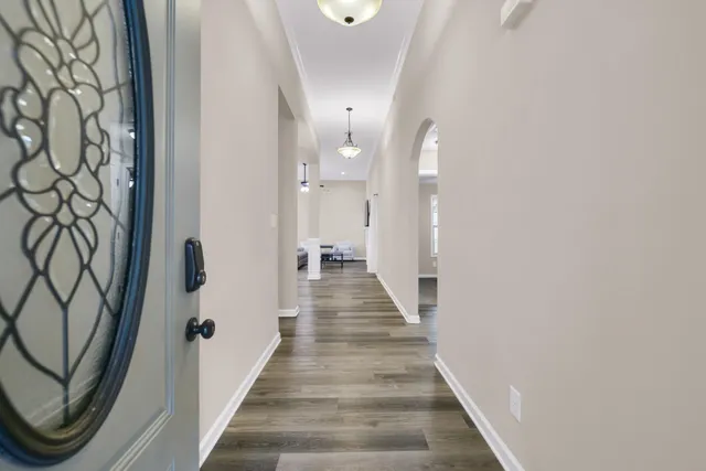 a view of a hallway with wooden floor and staircase