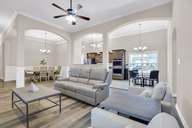 a living room with furniture a fireplace and a chandelier