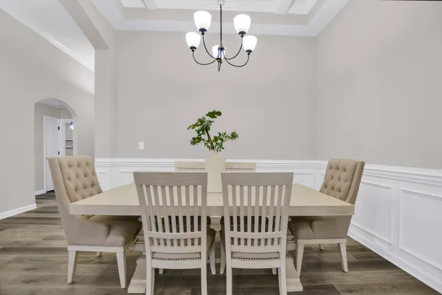 a view of a dining room with furniture a chandelier and wooden floor