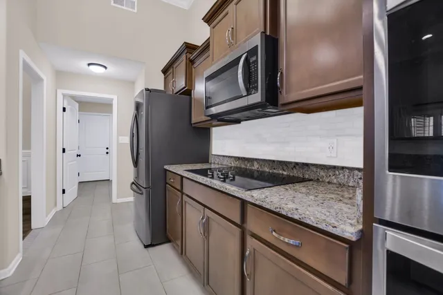 a kitchen with stainless steel appliances granite countertop a refrigerator and a stove