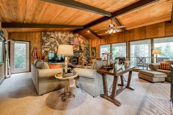 a living room with fireplace furniture and a large window