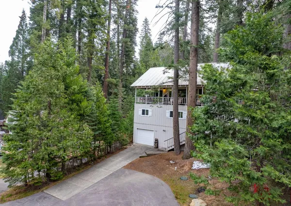 a aerial view of a house with a yard and large trees