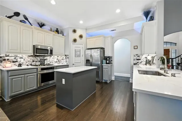 a kitchen with a sink stove and cabinets