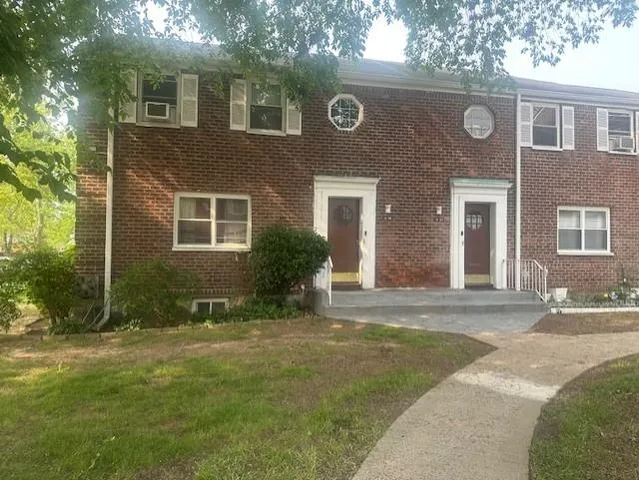 a front view of a house with a yard and potted plants