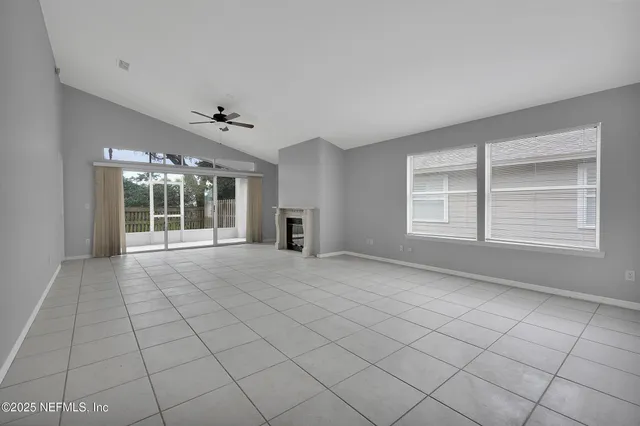 a view of an empty room with a fireplace and a window
