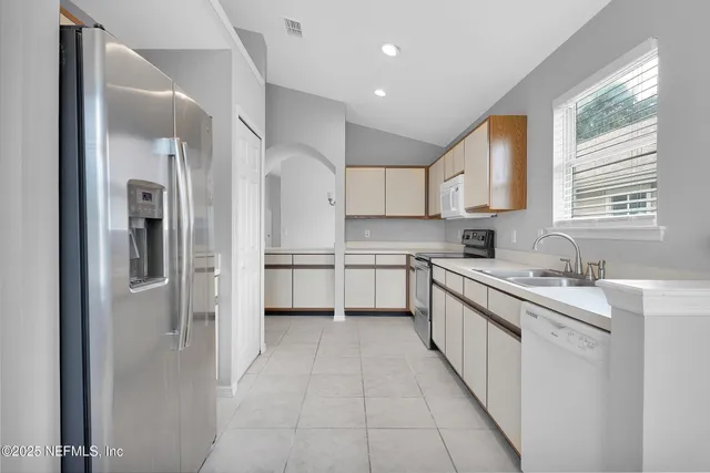 a kitchen with stainless steel appliances granite countertop a refrigerator and a sink