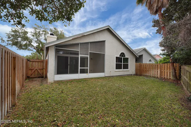 an empty room with windows and view of a livingroom