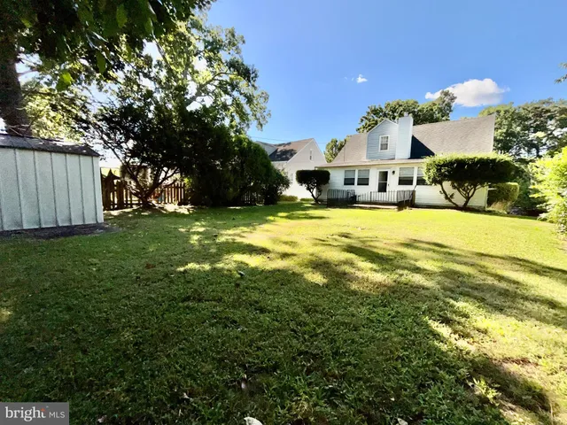 a backyard of a house with plants and large trees