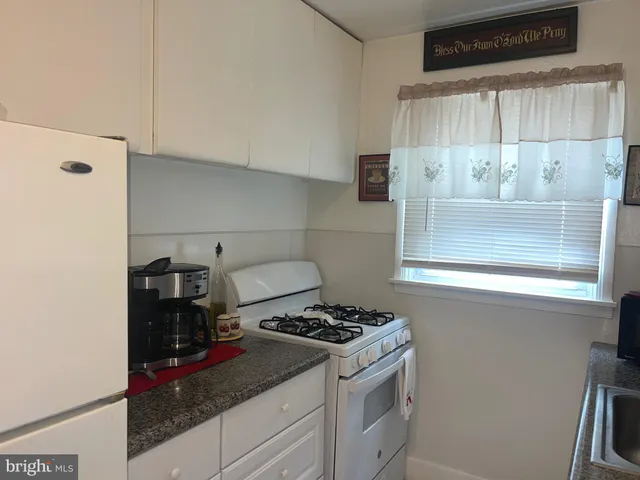a kitchen with a sink a stove and cabinets