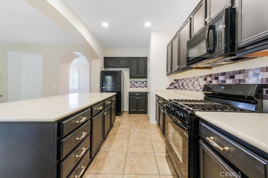 40530 Amador Drive Indio, CA 92203 - Photo 24 of 59 a kitchen with stainless steel appliances granite countertop a stove top oven a sink dishwasher and a microwave oven with white cabinets