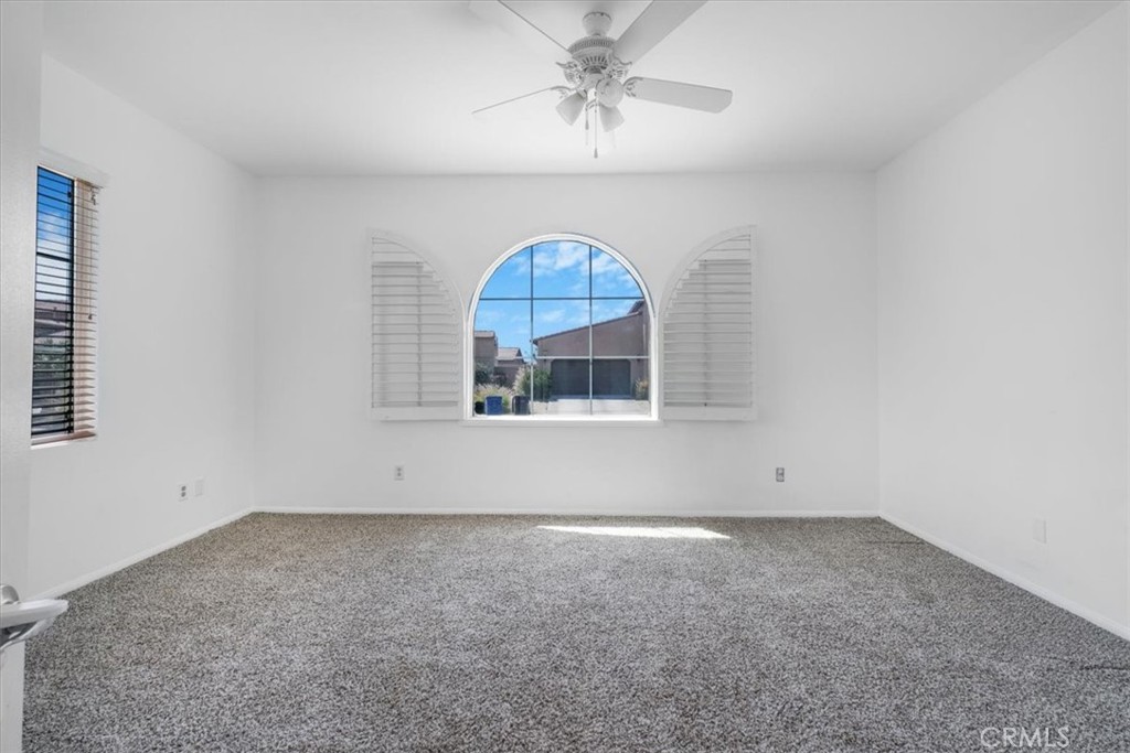 40530 Amador Drive Indio, CA 92203 - Photo 5 of 59 an empty room with a chandelier fan and wooden floor