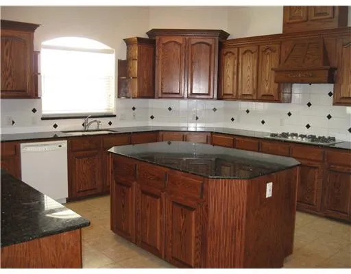 a kitchen with stainless steel appliances a sink stove and cabinets