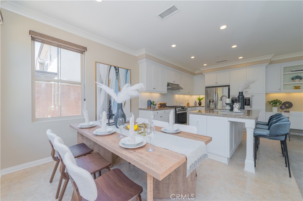 93 Rembrandt Irvine, CA 92620 - Photo 11 of 26 a open dining room with stainless steel appliances a table and chairs
