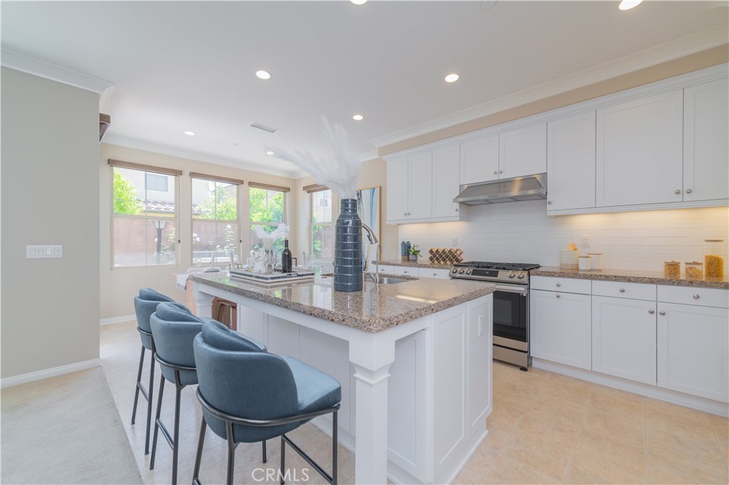 93 Rembrandt Irvine, CA 92620 - Photo 6 of 26 a kitchen with granite countertop white cabinets and stainless steel appliances