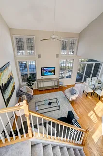 a living room with furniture a flat screen tv and a table