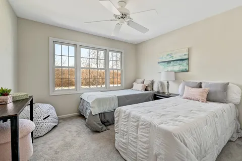 a bedroom with two beds and a large window