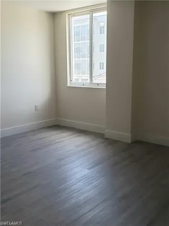 an empty room with wooden floor and mirror