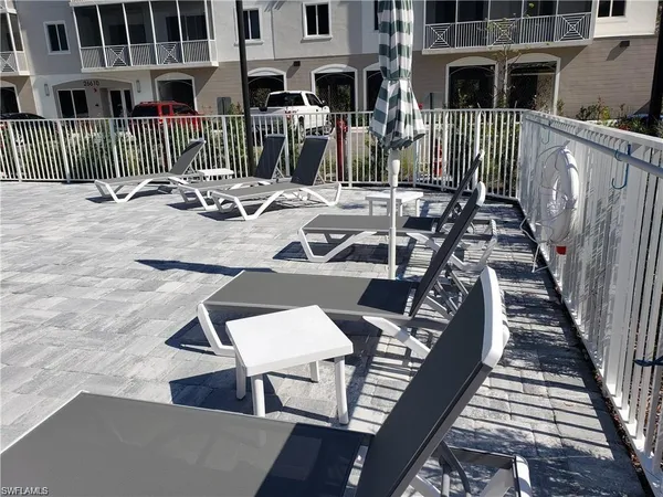 a view of a patio with chairs and potted plants