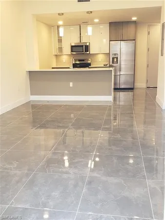 a view of kitchen with stainless steel appliances a refrigerator sink and cabinets