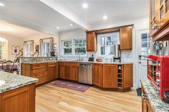a large kitchen with granite countertop a sink and cabinets