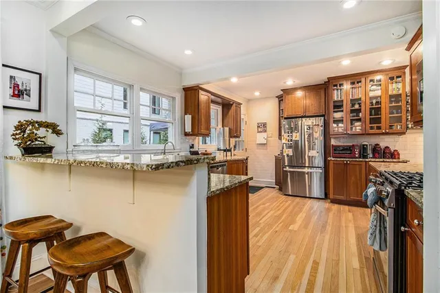 a kitchen with stainless steel appliances granite countertop a refrigerator and a stove top oven