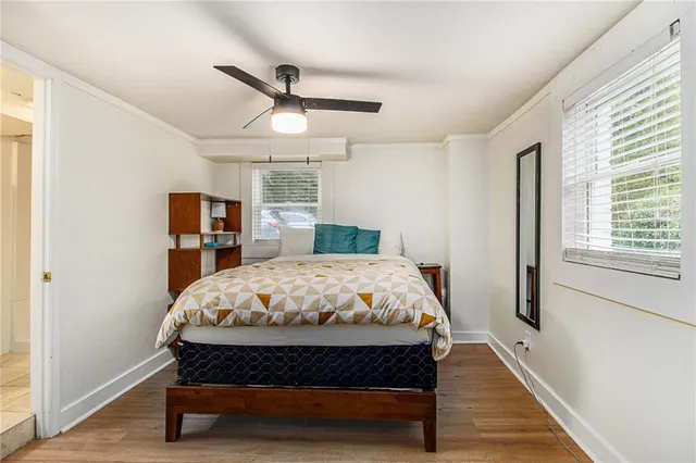 a bedroom with a bed a dresser and a large window