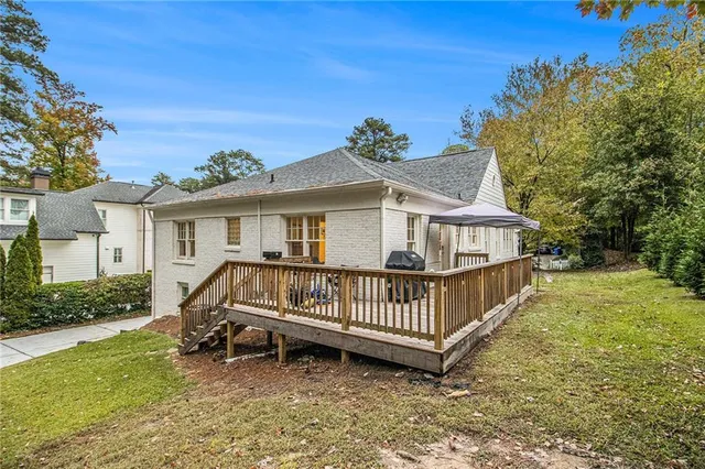 a view of a house with a wooden deck and a yard