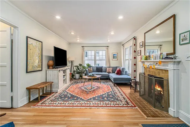 a living room with furniture a flat screen tv and a fireplace