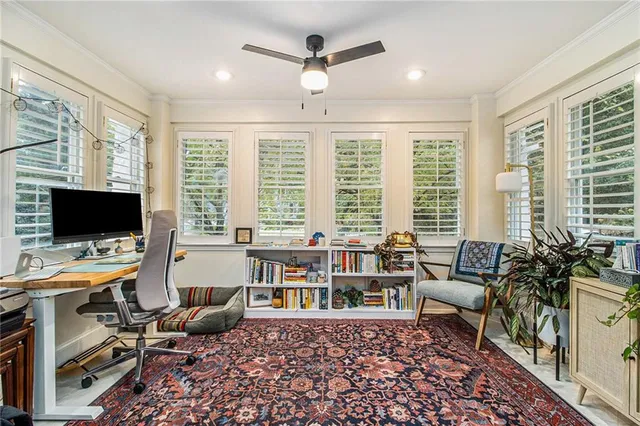 a view of a livingroom with workspace and a window