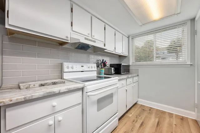 a kitchen with stainless steel appliances granite countertop a sink a stove and cabinets