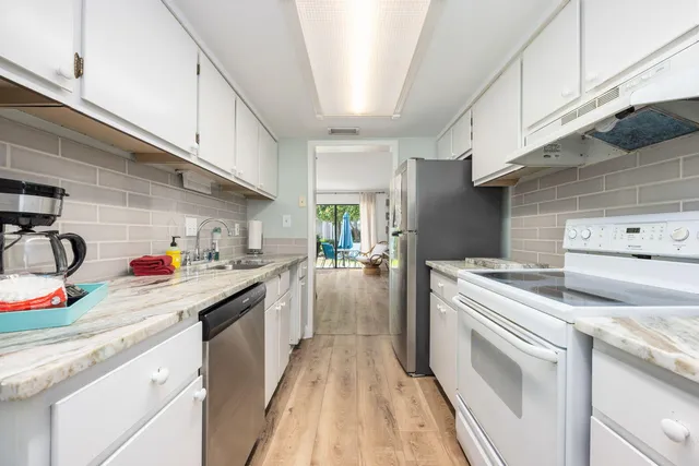 a kitchen with kitchen island a sink stove and cabinets