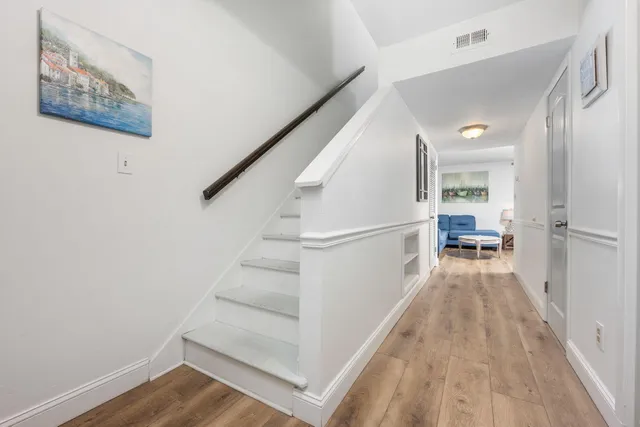 a view of a hallway with wooden floor and staircase