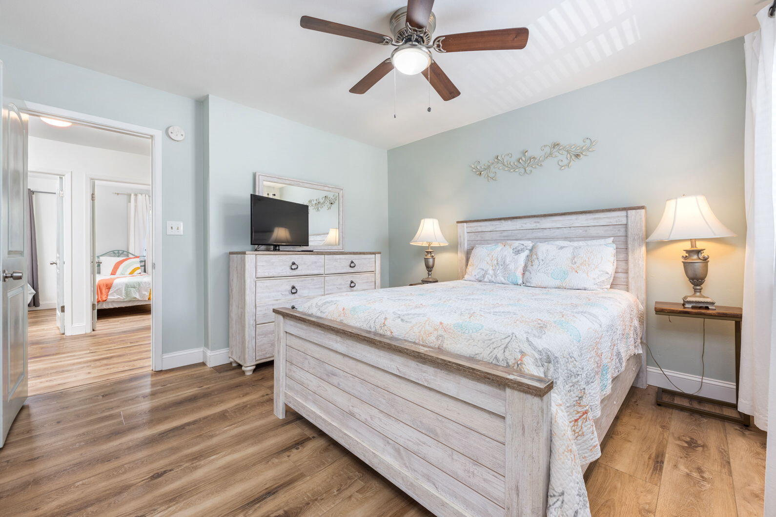 940 Highway 98, Unit 31 Destin, FL 32541 - Photo 21 of 36 a bedroom with a large bed a flat tv screen and a chandelier