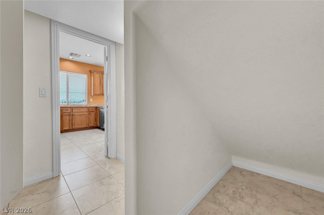 977 Sparkling Light Street Henderson, NV 89052 - Photo 37 of 75 This interior captures a well-lit kitchen entrance with durable tile flooring.